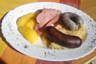 Blut- und Leberwurst mit Schwarte auf Sauerkraut, dazu Salzkartoffeln